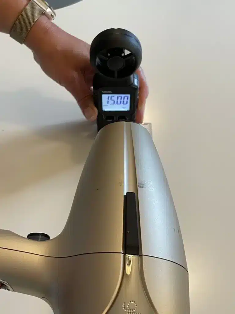 Mata-blashastighet Testlabbet mäter luftflödet från en hårfön med digital anemometer