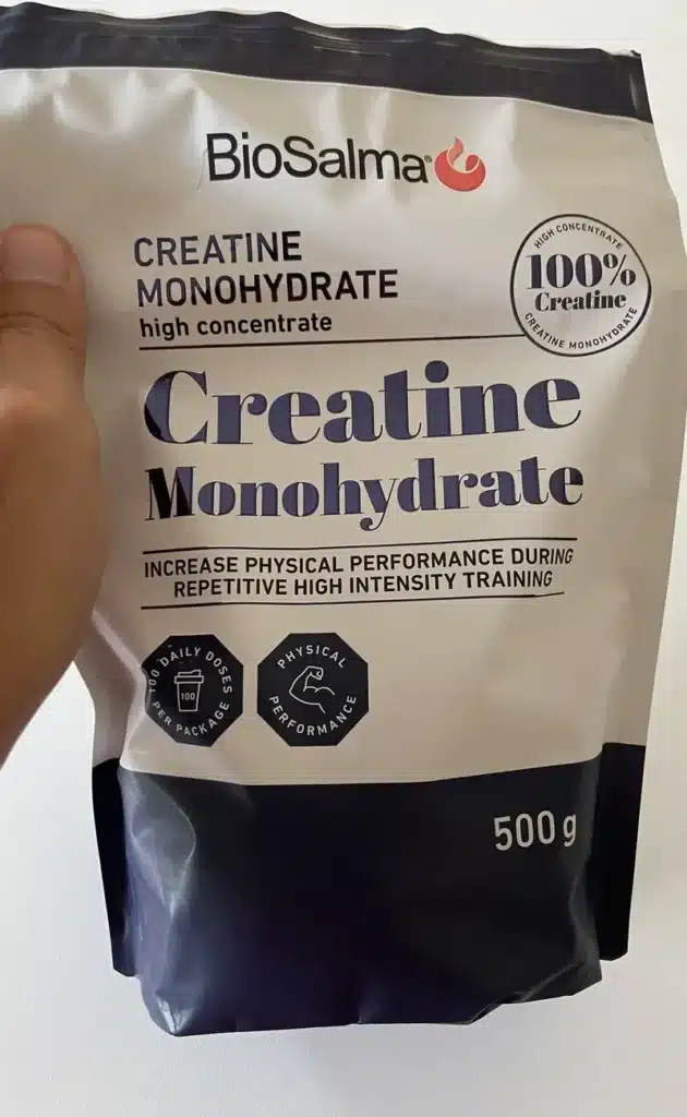 Test-av-BioSalma-Creatine Hand som håller en förpackning Biosalma Creatin pulver inför produkttest