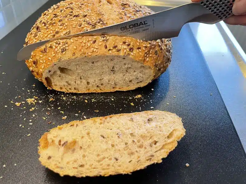 Kniv skär surdegsbröd i vårt praktiska test av knivset